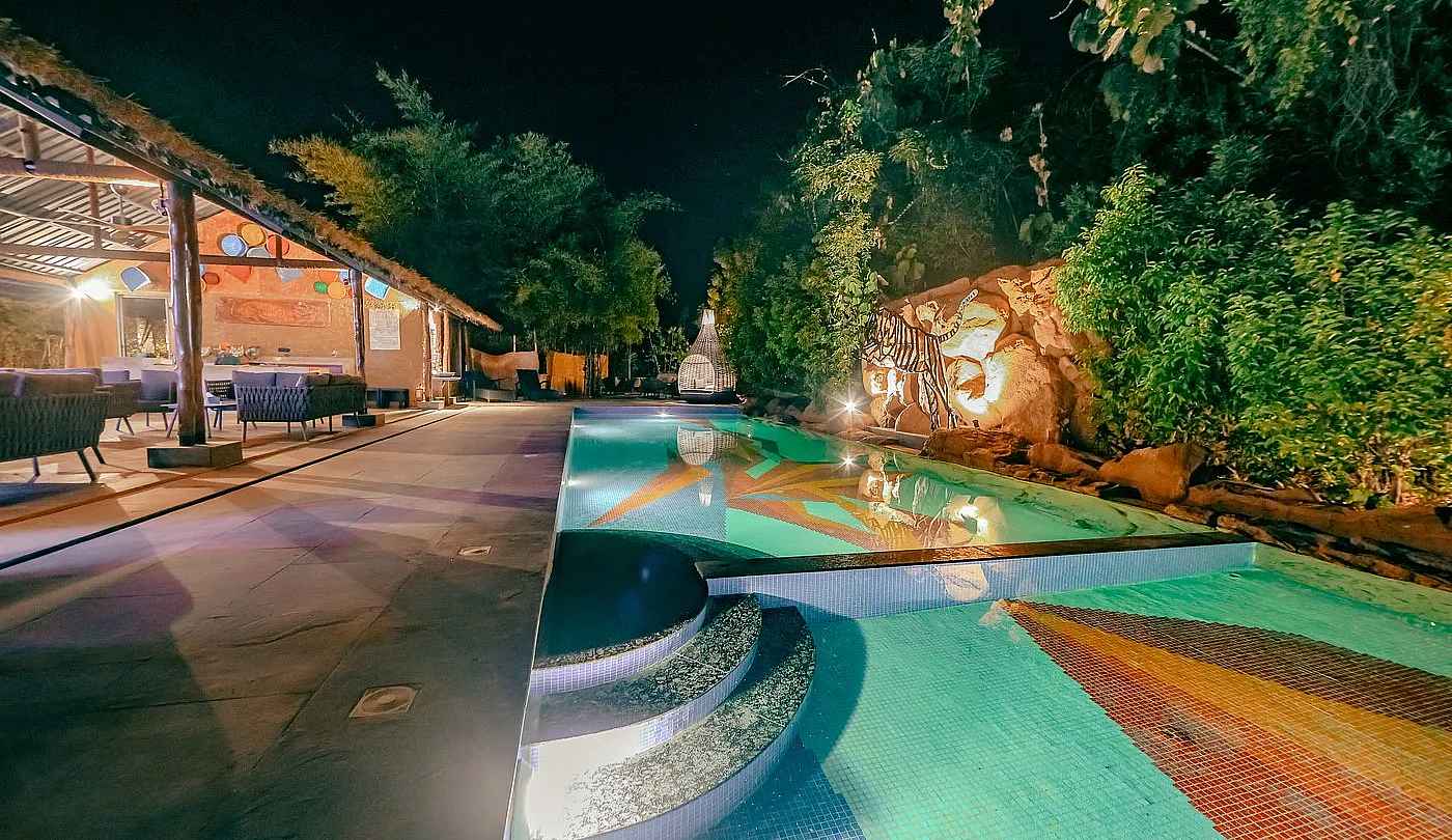 Limban Resort's illuminated evening pool—the most intimate luxury safari resort near Tadoba's Moharli and Khutwanda Gates.